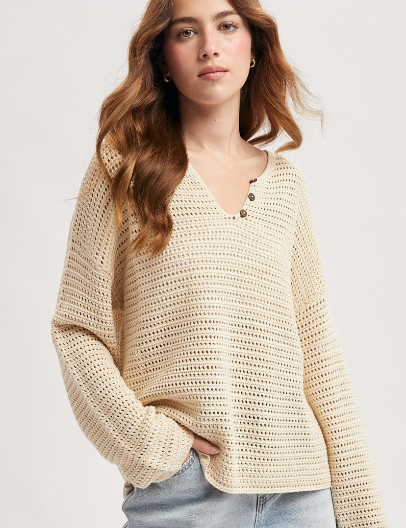 Beige long sleeved, loose knit sweater with notch neck