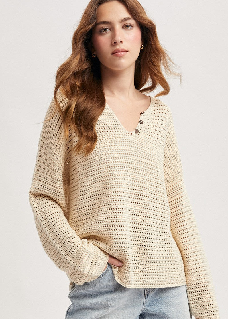 Beige long sleeved, loose knit sweater with notch neck