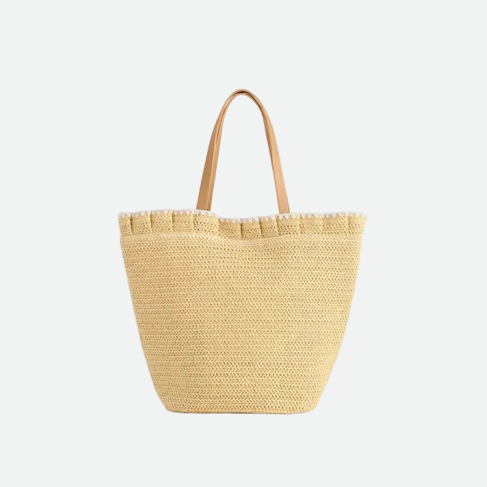 Beige woven tote bag with a tan handle on a white background