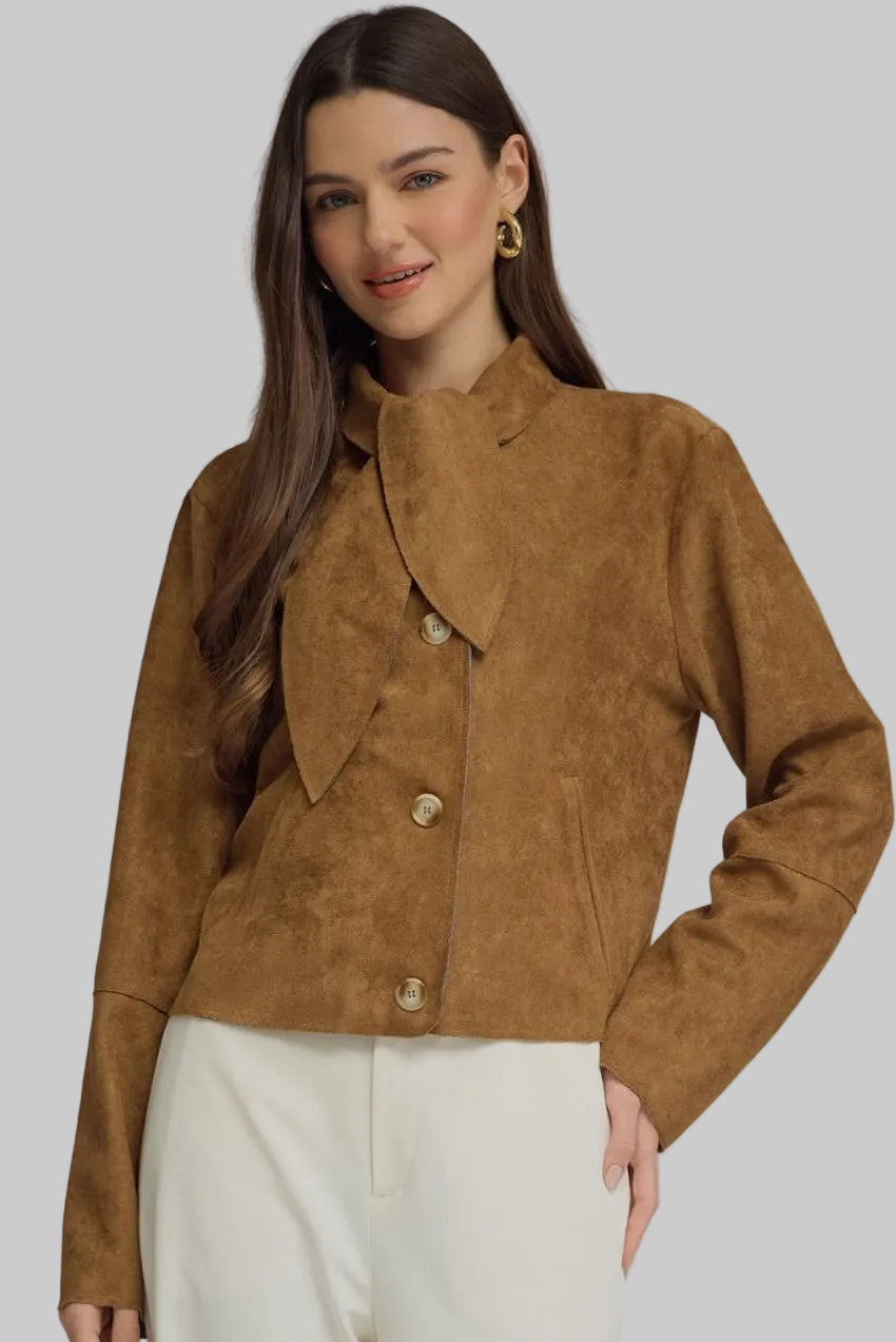 Woman wearing a camel brown suede-look jacket with scarf-tie neckline, button front