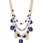 A gold-tone statement necklace featuring a multi-strand beaded design with blue and white beads, football-shaped charms, and a central beaded word charm spelling 'FAMILY DAY'.