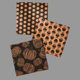 Three Halloween-themed fabric dishcloths with pumpkin, polka dot, and acorn patterns.
