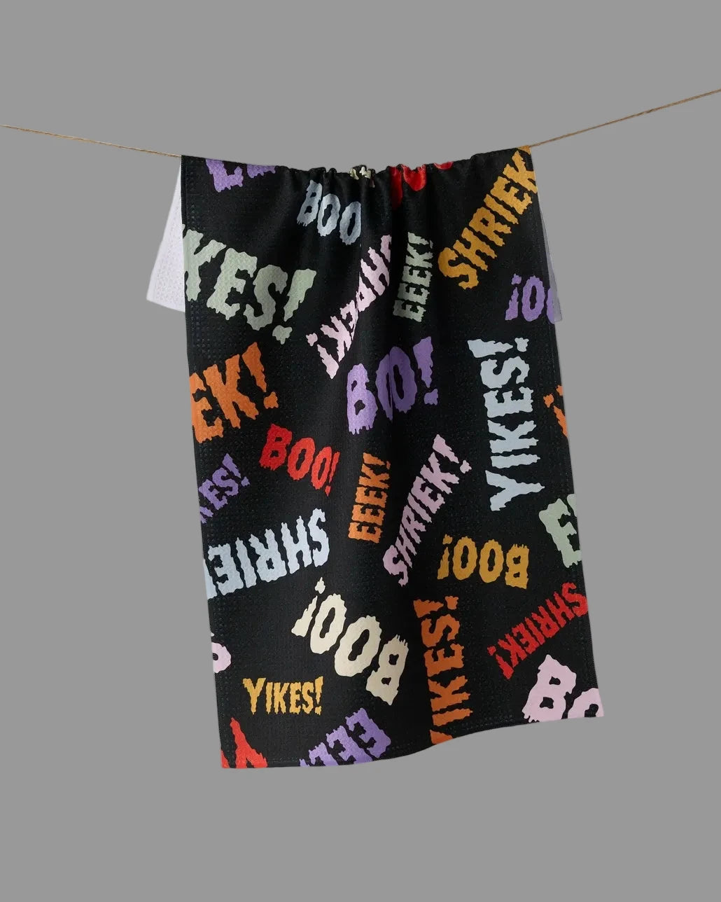A black towel. The fabric is covered in colorful repeated text including BOO, YIKES!, EEEK!, SHRIEKS!, and LIZAH.