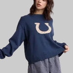  a navy blue crewneck sweater with a large horseshoe graphic on the chest