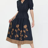 short sleeved navy blue dress with brown floral appliques on the skirt 