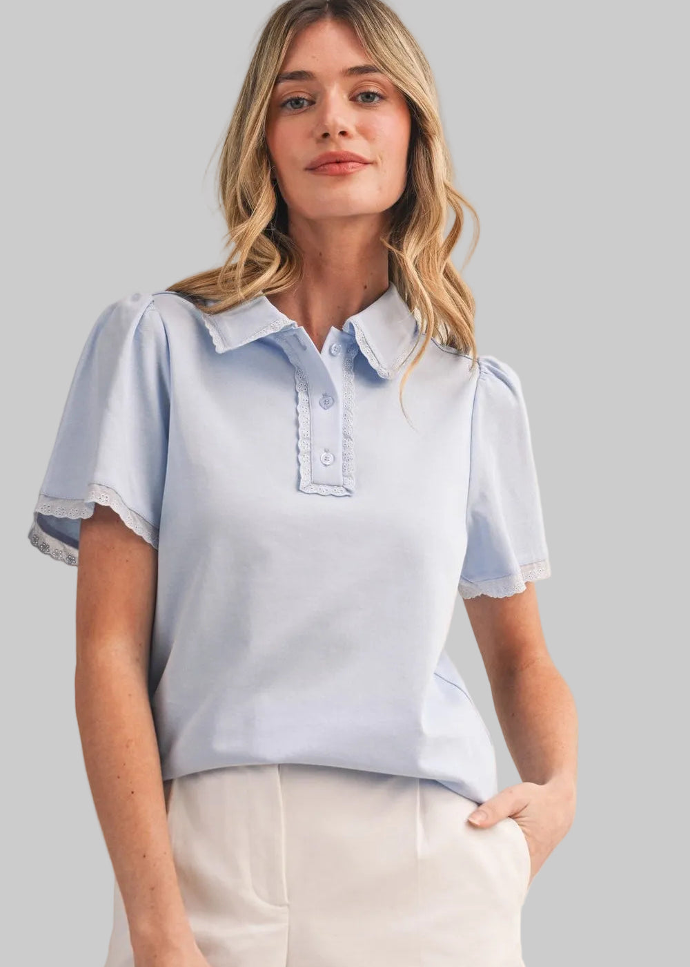Light blue polo shirt with short sleeves and lace trim collar, cuffs, and placket