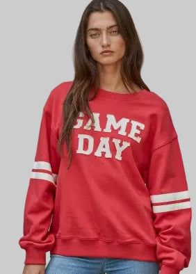 Red sweatshirt with cream game day lettering.  Long sleeves with two cream stripes