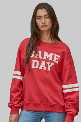 Red sweatshirt with cream game day lettering.  Long sleeves with two cream stripes