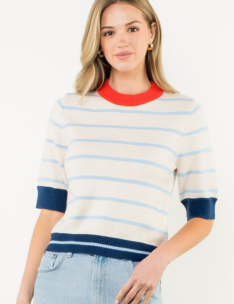 Woman wearing a striped sweater and denim skirt on a white background