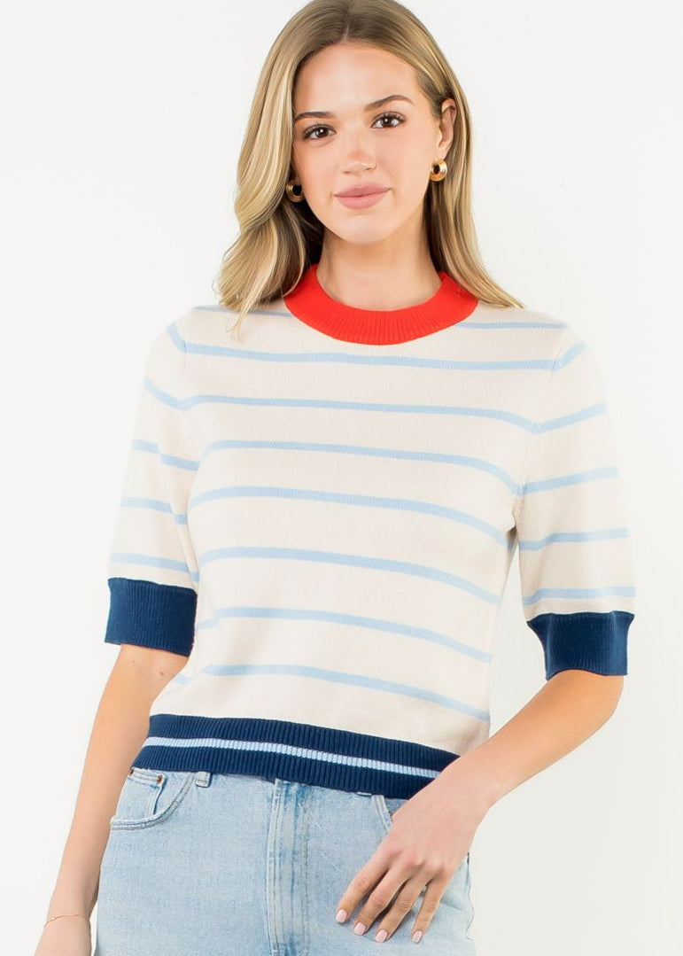 Woman wearing a striped sweater and denim skirt on a white background