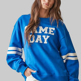 bright blue crewneck sweatshirt with 'GAME DAY' printed in white across the chest and white stripes on the sleeves