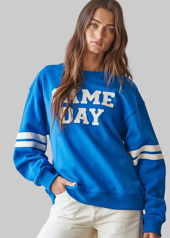 bright blue crewneck sweatshirt with 'GAME DAY' printed in white across the chest and white stripes on the sleeves