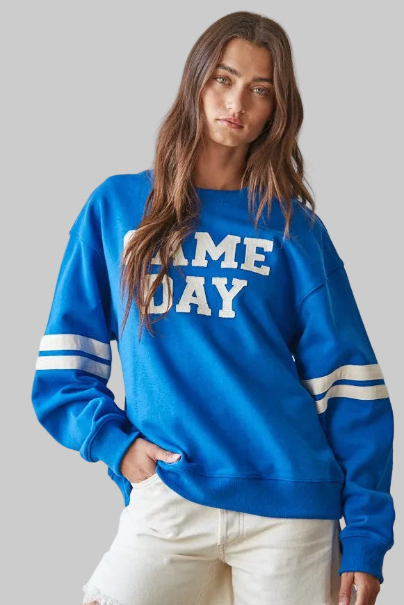 bright blue crewneck sweatshirt with 'GAME DAY' printed in white across the chest and white stripes on the sleeves