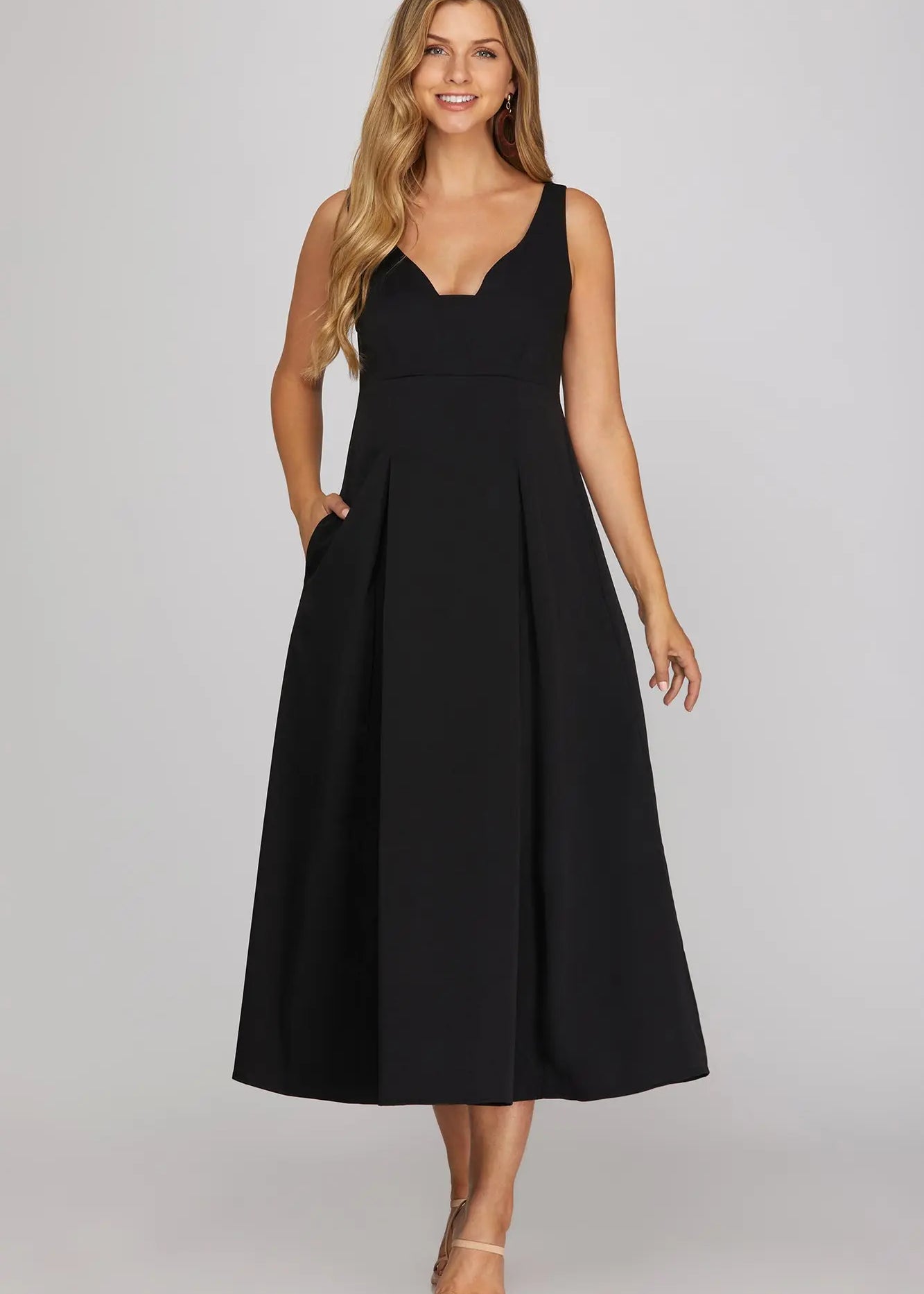 sleeveless black midi dress with a V-neckline and pleated skirt