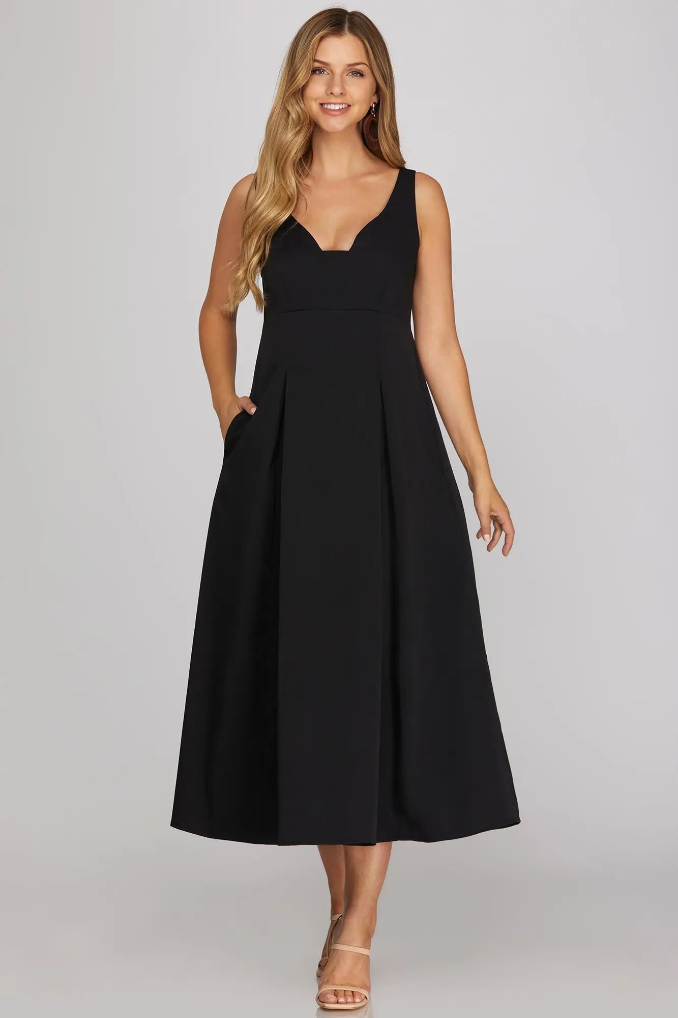 sleeveless black midi dress with a V-neckline and pleated skirt